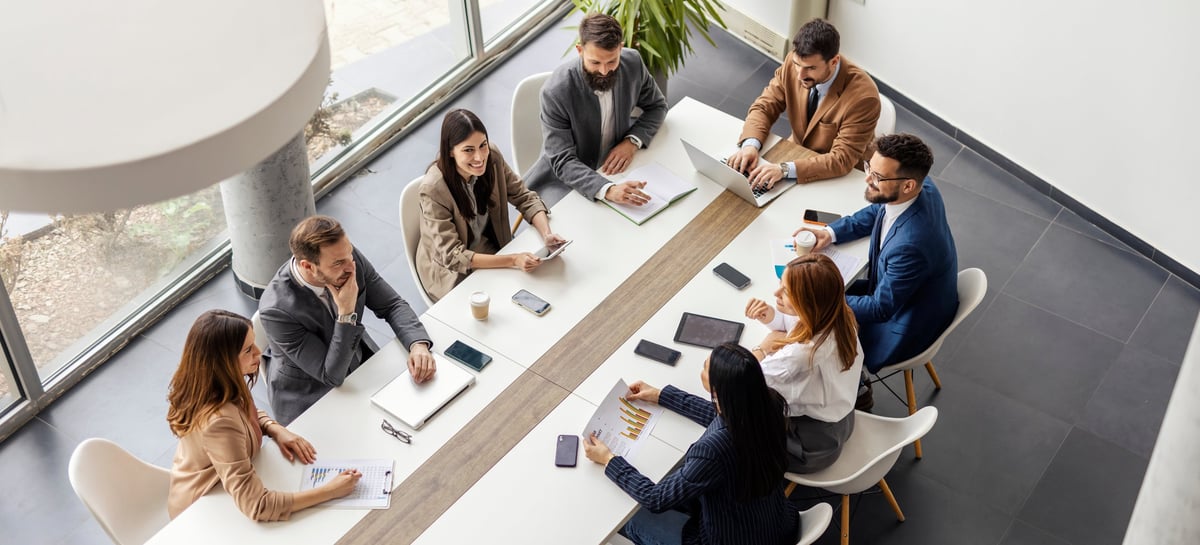 Leadership team seated at a boardroom conference table in discussion