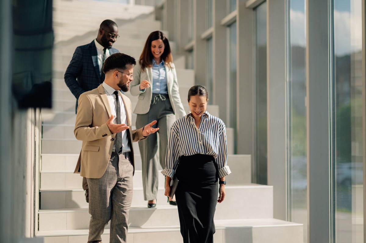 Multi-ethnic business team walking down stairs in a modern office