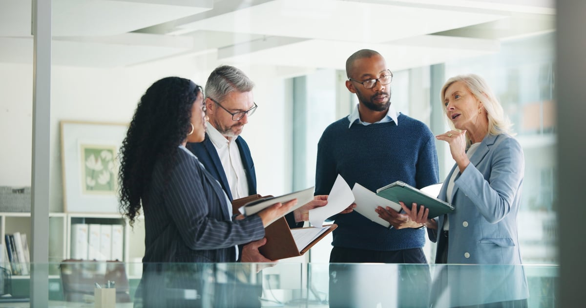 Business team reviewing financial documents and reports around a meeting table